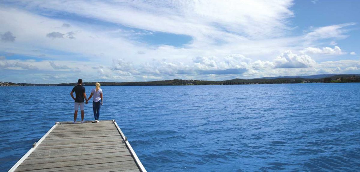 Couple standing at the end of a jetty