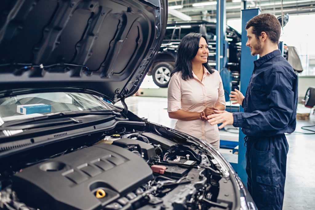 Car service center scene. The mechanic communicates with the client